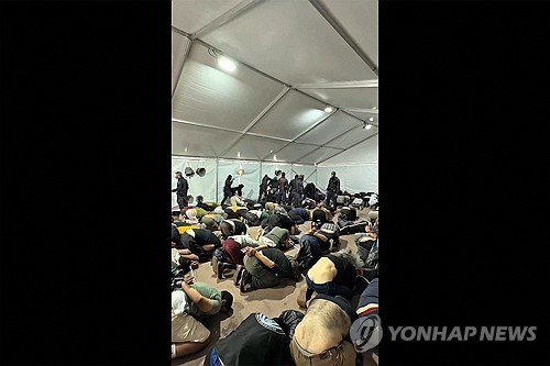 이스라엘군 임시 수용소에서 두 손이 묶인 채 무릎을 꿇고 있는 구호선단 활동가들