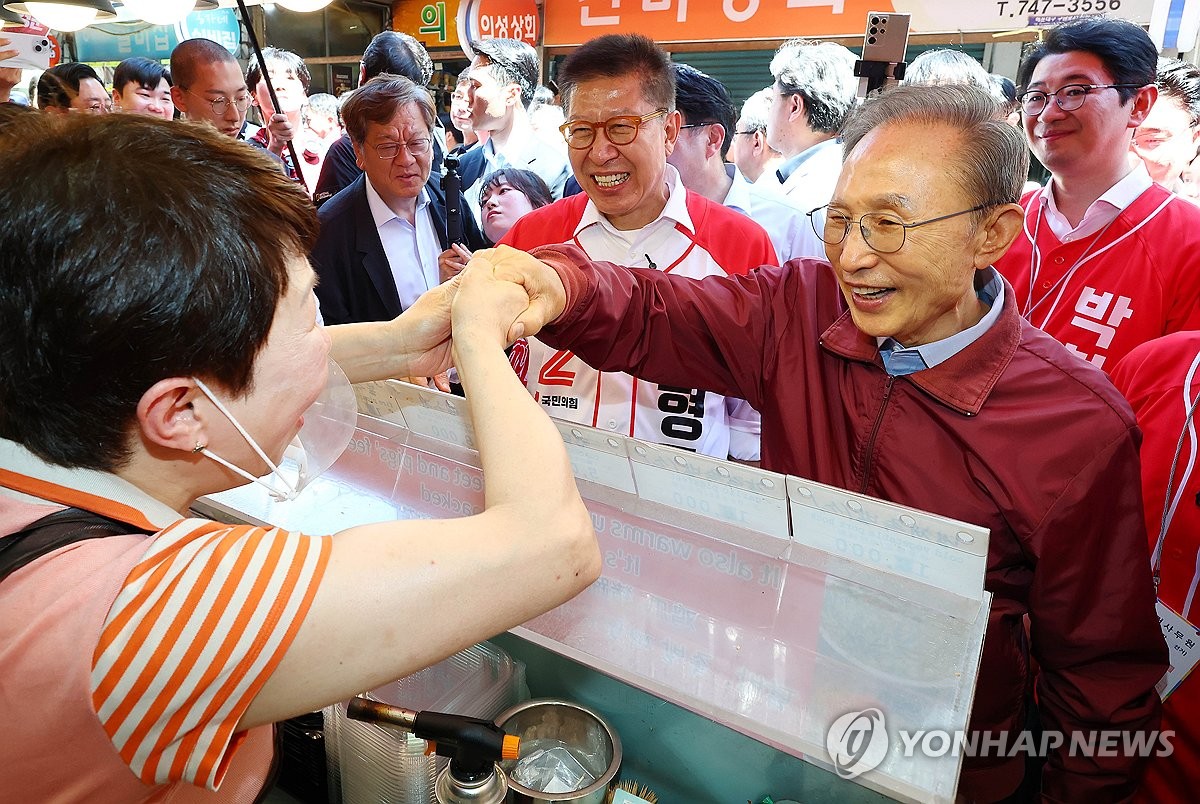 상인과 인사하는 이명박 전 대통령
