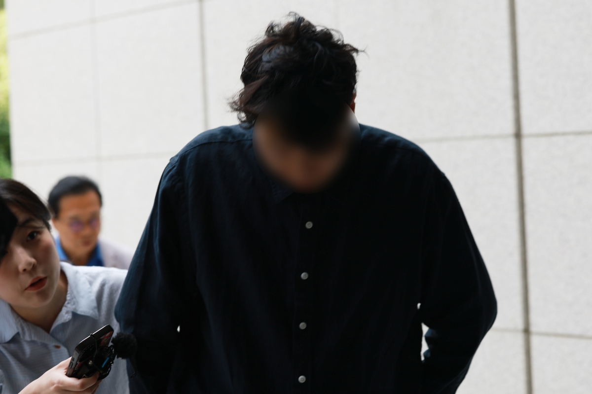고개 숙인 '외국인 폭행 혐의' 섬유 제조업체 대표 