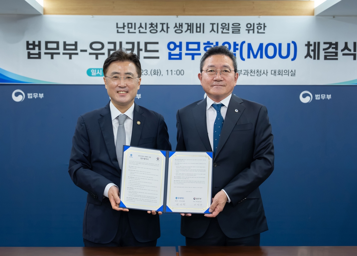 진성원 우리카드 대표이사(오른쪽)와 이진수 법무부 차관, 업무협약 체결 기념 촬영