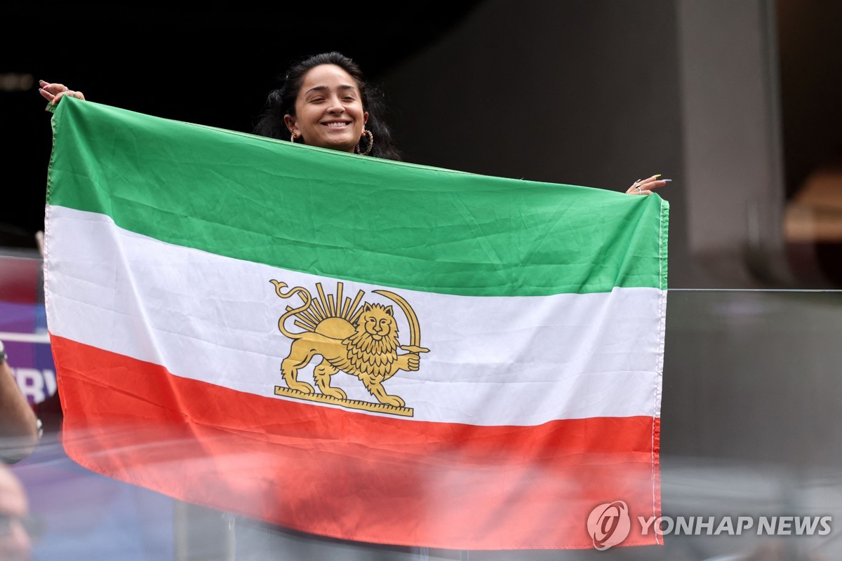 '사자와 태양' 문양이 새겨진 옛 이란 국기를 든 월드컵 관람객