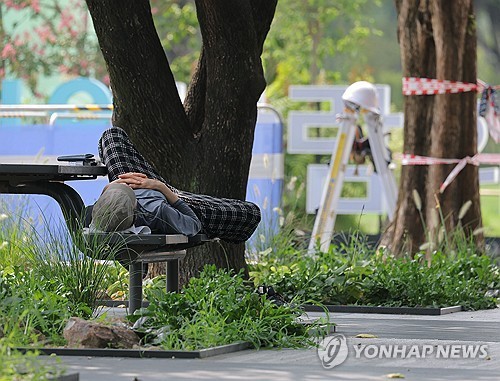 폭염에 나무 그늘에 누운 시민
