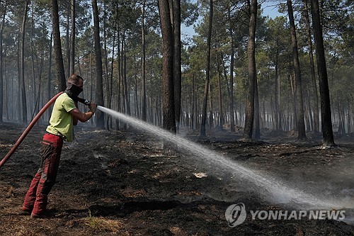 프랑스 남서부 산불 현장에서 지역 주민이 호스로 잔불을 끄고 있다.