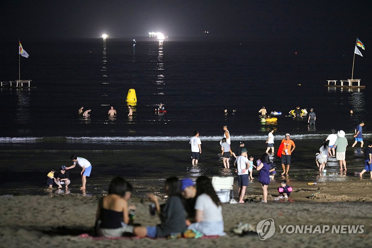 제주 해수욕장에서 밤 더위 식히는 사람들