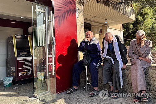 방크 미스르 ATM 앞에 앉아 있는 이집트 시민들