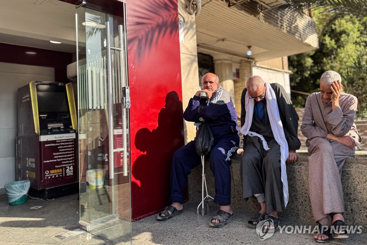 방크 미스르 ATM 앞에 앉아 있는 이집트 시민들